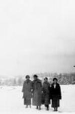 Four women stand outside in the snow.