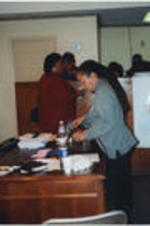 Participants at a "Get Out The Vote" phone bank event are gathered in an office space with food and drink.