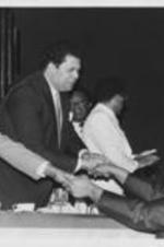 Mayor Maynard Jackson is shown shaking hands with Joe Boone at the annual Southern Christian Leadership Conference Awards dinner held as part of the SCLC National Convention. Written on verso: SCLC Awards Banquet -- Atlanta Mayor Maynard Jackson (2nd from left) greets Atlanta clergyman Joe Boone following his address at the Southern Christian Leadership Conference's Annual Awards Dinner held each year during the SCLC National Convention. SCLC Board Member Nelson H. Smith (left) also greets Boone as Dr. Ralph D. Abernathy looks on from behind Jackson. Standing beside Jackson is SCLC President Joseph E. Lowery.