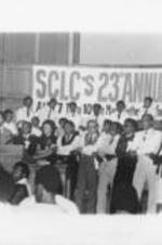 Joseph and Evelyn Lowery, Walter E. Fauntroy, Benjamin Hooks, and others are shown holding hands and singing during the 23rd Annual Southern Christian Leadership Conference Convention