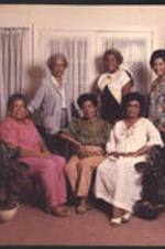 Six daughters of John and Irene Dobbs pose together in a living room.