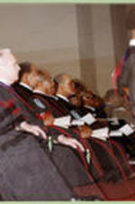 Platform participants (President, Board of Trustees, and Deans) look on during graduation proceedings.
