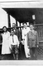 George A. Towns and family stand outside of a home.