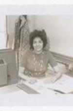 A portrait of secretary, Mrs. Doris Smith writes at a desk. Written on verso: CC, Mrs Doris Smith, Secretary, Presidents Office, 1965, yearbook p. 32.