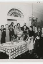People stand around a banquet table.