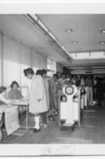Women stand in line and register to vote. Written on verso: Voter registration, Augusta, GA.