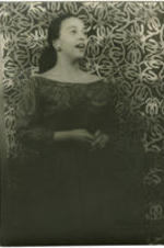 Portrait of Adele Addison singing in front of a patterned background. Written on verso: Photograph by Carl Van Vechten; 146 Central Park West; Cannot be reproduced without permission; April 8, 1955.