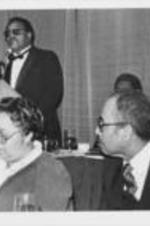 Dr. O.C. Jones pays tribute to Ralph D. Abernathy at an event organized to recognize Abernathy's contributions to the civil rights movement. Written on verso: Dr. O.C. Jones pays tribute to Dr. Abernathy as Bishop and Mrs. Joseph Coles listen attentively. For more details about the event documented in this photograph, see pages 122-125 of the January-February 1986 SCLC Magazine: https://radar.auctr.edu/islandora/object/auc.199%3A07028.