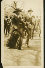 Unidentified woman and man walking in front of group of people.