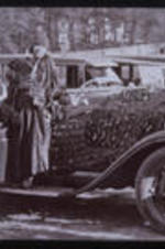 Two women stand in front of a car. Text from slide presentation: Clark University and Gammon Theological Seminary remained the focus of community life, but in 1941, Clark relocated to west Atlanta and Gammon followed 20 years later.