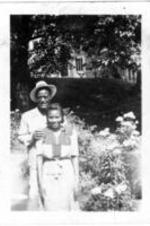 An unidentified couple stand outside in a yard.
