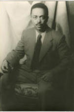 Portrait of Peter Abrahams sitting in a chair. Witten on verso: Peter Abrahams; Photograph by Carl Van Vechten; 146 Central Park West; Cannot be reproduced without permission; Nov. 25, 1955.
