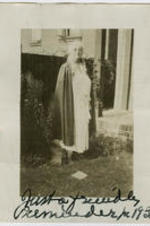 Mary McDowell standing in yard. Written on verso: Miss Mary Mc Dowell at Chicago U. settlement house at stack yards. Written on recto: Just a friendly reminder 1931.