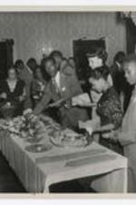 People stand around a banquet table.