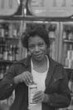 An unidentified woman holds a can of beer in a liquor store.