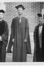 Dr. Harry Richardson stands with two graduates during commencement.