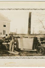 Men stand next to a cart of lumber during the construction of Harkness Hall. Written on verso: Construction of Atlanta University's Administration Building