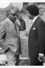 Dr. Bacote speaks with Maynard Jackson. Written on verso: Left to Right: Dr. Clarence A. Bacote, Mayor Maynard H. Jackson. Photographer: Harmon Perry, May 21, 1977. 1470 Orlando St. S. W., 3011