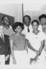 Dick Gregory is shown posing in front of a blackboard with Brenda Davenport and others at a youth rally event during the 28th Annual Southern Christian Leadership Convention in Montgomery, Alabama.