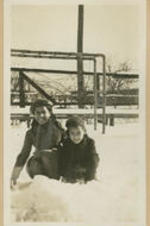 Two girls play in the snow.