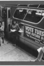 Women hand our voter education flyers in front of a bus alongside John Lewis. Written on verso: John Lewis, circa 1965-1973, Alabama (?).