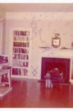 Pet dog near fireplace. Written on verso: President John Kennedy's son was in women's dormitory for freshmen. Guidance the last year they residents of Mass. Ted accepted a sabbatical leave till they established residence at Portland [?].