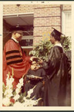 Dr. Vivian Wilson Henderson presenting a graduate with her degree at a commencement ceremony at Clark College in Atlanta, Georgia.