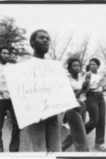 An Alabama State University student with a "ASU - Yesterday, Today, Tomorrow" sign is shown leading other ASU students in a march.