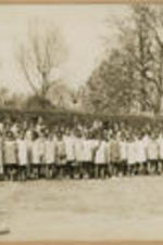A large group of children gather outside.