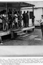 John Lewis and Julian Bond speak to people during their Voting Rights Tour. Written on recto: Whit castle, LA. - John Lewis and Julian Bond (right) speak to a group of black citizens during their recent Louisiana Voting Rights Tour, August 3-5, 1971. As officials of the Voter Education Project (VEP), their efforts were an attempt to encourage the registration of almost 200,000 unregistered blacks in the State of Louisiana. (Photo by Archie E. Allen).