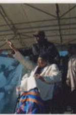 Amelia Boynton Robinson waves to the crowd as Faya Ora Rose Toure (at left) speaks during the Selma Bridge Crossing Jubilee event.
