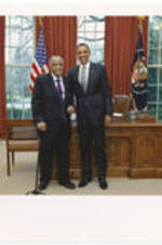 Joseph E. Lowery poses for a photo with President Barack Obama in front of the Resolute Desk in the Oval Office of the White House.