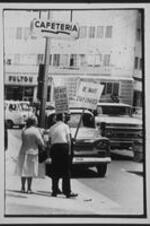 Segregationists protest outside of a restaurant holding signs reading: "Be Smart, Stay Unmixed", and "Do Not Eat Here, The Owner of This Business is a Leader for Integration".
