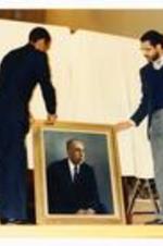 President Hugh Gloster with unidentified persons and portraits dedicated to Morehouse College.