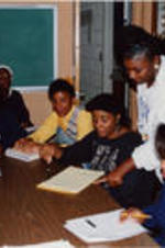 A woman is shown engaging with a group of women at the SCLC/W.O.M.E.N. Learning Center.