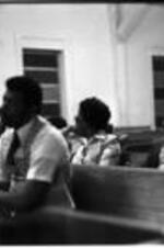 Two men and two women sit in a church pew during a VEP meeting.