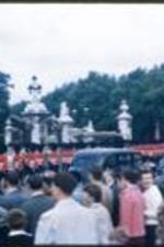 Procession in front of Buckingham Palace with Queen's guards and automobiles.