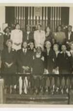 Indoor group portrait of men and women in a church. Written on verso: Dr Mary M. Bethune, Women's Day Speaker 1954, Mrs B's last public appearance in State.