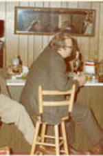 C. Eric Lincoln sits at a bar in a house, part of a visit to the University of Kentucky.