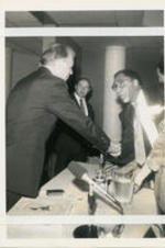 Joseph E. Lowery and Jimmy Carter are shown shaking hands during a Carter Center Conference on Democracy in the Americas. Written on verso: Lowery shakes hands with Carter before one round of meetings begins. After the conference ended Carter talked privated [sic] with Lowery about human rights.