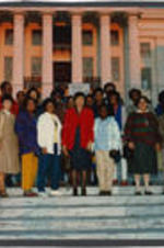 Evelyn G. Lowery (middle) is shown posing with a group of people in front of the Alabama State Capitol.