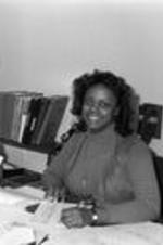 An unidentified woman smiles from behind her desk in a VEP office.