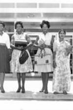 Four female students pose outside an ITC building. Written on verso: Students, Spring 1963. Miss Rosa Moore, Mrs. Myra Taylor, Miss Lydia Tucker, Miss Sukumari Hakum.