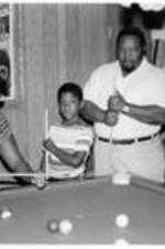 C. Eric Lincoln plays pool with his children Less Charles and Hilary Anne.