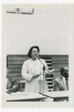 View of woman at a microphone. Written on verso: "Dean Magnoria Smothers; Vice President for Student Affairs, 1982".