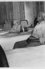Elderly men sit beside their beds at the Happy Haven Nursing Home, now named Sadie G. Mays Health and Rehabilitation Center.