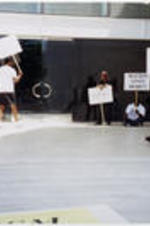 Joseph E. Lowery and other demonstrators sit and stand with protest signs outside of the Creative Artists Agency in Beverly Hills, California.