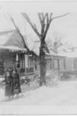 Anna E. Hall standing outside with a woman in winter. Written on verso: 1st house (Miss Hall); Left to Right: 1. Miss Anna E. Hall 2. Mrs. Joseph J. Dennis (Sammye) ca. 1940.