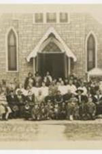 Outdoor group portrait of men and women in front of church. Written on recto: St. Paul's A.M.E. Church, Madison, Wis Nov 19, 1944.