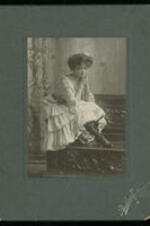 Portrait of Daisy Cheatham kneeling on chair without a hat.